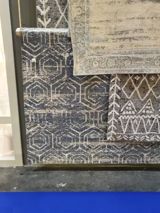 Alfombra azul y gris con motivos geométricos