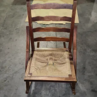 Vecchia sedia a dondolo in legno e iuta