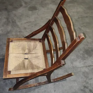 Vecchia sedia a dondolo in legno e iuta