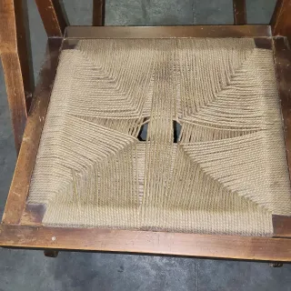 Vecchia sedia a dondolo in legno e iuta