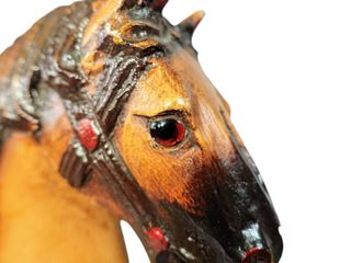 Antiguo caballo de madera sobre plataforma con ruedas de hierro.