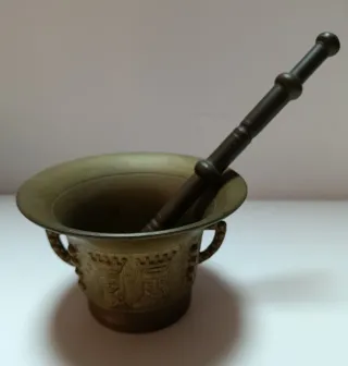 Mortero antiguo de bronce con los Reyes Católicos.