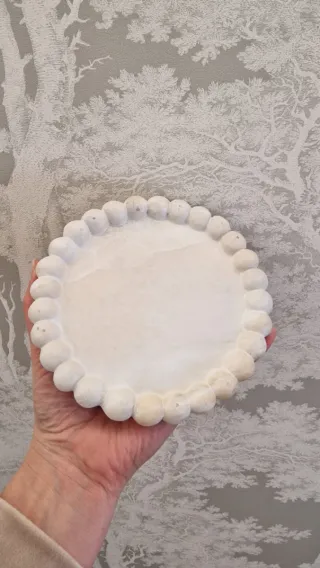 Plato decorativo de piedra con borde de bolitas