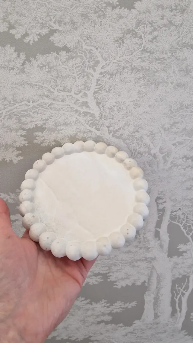 Plato decorativo de piedra con borde de bolitas