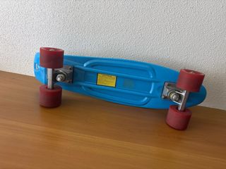 Monopatín azul con ruedas rojas