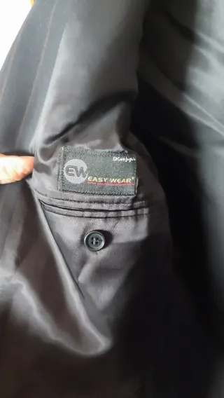 Traje de hombre negro con raya discreta en marrón.