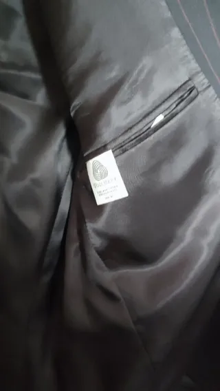 Traje de hombre negro con raya discreta en marrón.