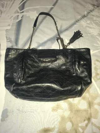 Bolso negro con cadena y detalle de flecos