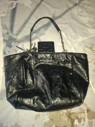 Bolso negro con cadena y detalle de flecos