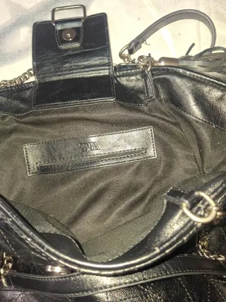 Bolso negro con cadena y detalle de flecos