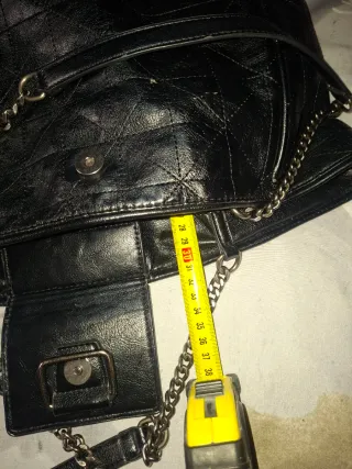 Bolso negro con cadena y detalle de flecos