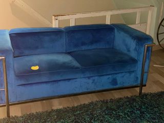 Sofá azul de terciopelo y base de metal