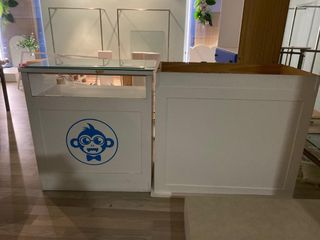 Mostrador blanco con logo de mono