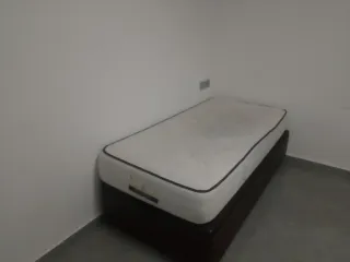 Cama individual con base tapizada. Regalo mesita