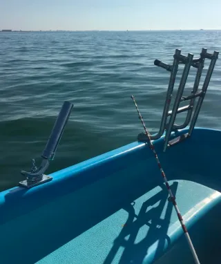 Embarcación azul con cañero y escalera