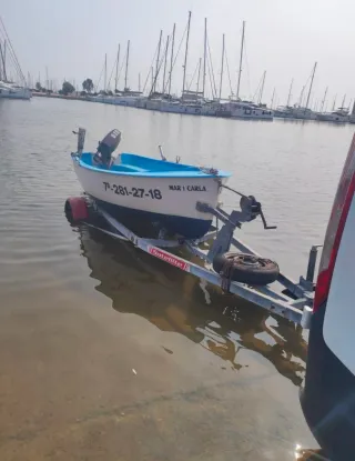 Embarcación azul con cañero y escalera