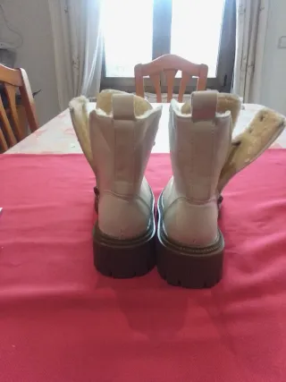 Botines beige con cordones y cremallera forradas.