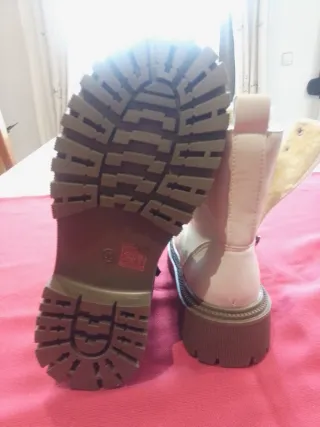 Botines beige con cordones y cremallera forradas.