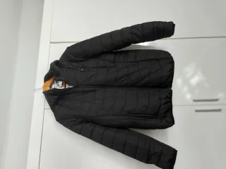 Chaqueta negra acolchada con capucha i calentador