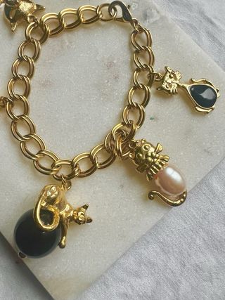 Pulsera dorada con charms de gatos y más