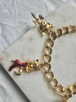 Pulsera dorada con charms de gatos y más