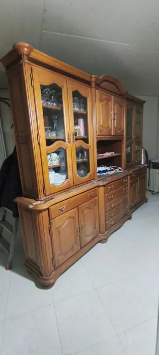 Mueble castaño con vitrina y cajones.