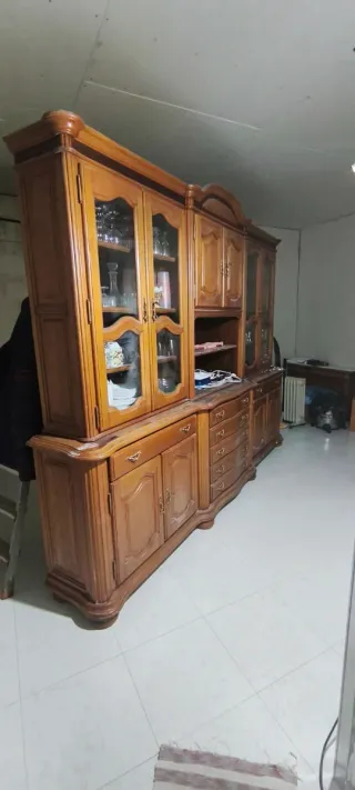 Mueble castaño con vitrina y cajones.