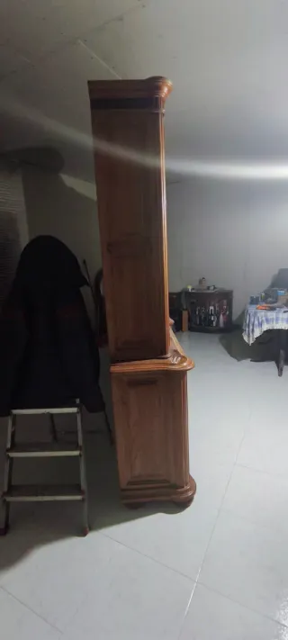 Mueble castaño con vitrina y cajones.