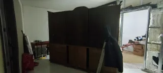 Mueble castaño con vitrina y cajones.