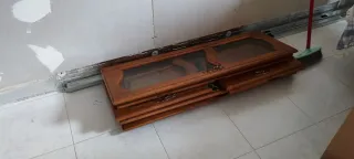 Mueble castaño con vitrina y cajones.