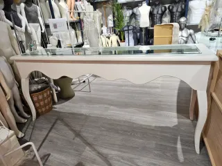 Mostrador isabelino blanco con vitrina de cristal.