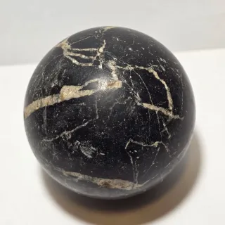 Antica sfera in marmo nero con venature bianche