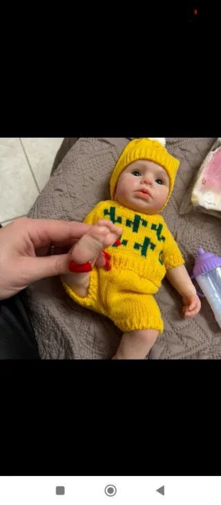 Muñeco bebé con conjunto de punto amarillo
