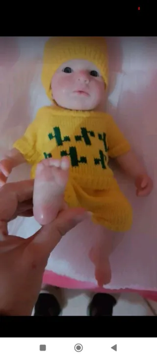 Muñeco bebé con conjunto de punto amarillo