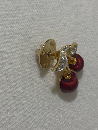 Pin de cereza y brillantes, no se la marca