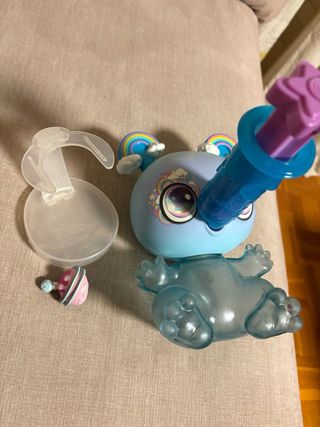 Muñeco azul con arcoíris y accesorio.