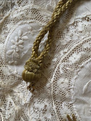 Reliquia religiosa antigua con cordón y borla