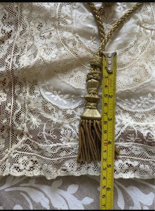 Reliquia religiosa antigua con cordón y borla