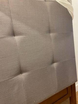 Cabecero gris tapizado con patas de madera