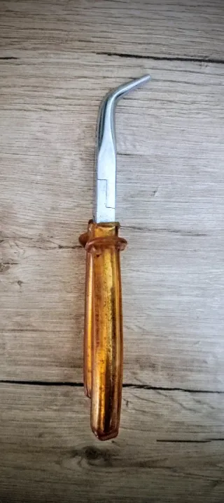 Pinza con becchi lunghi piegati e manico in gomma.