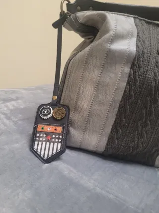 Bolso gris con detalle colgado en el lateral