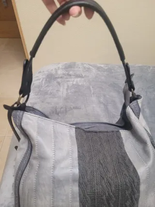 Bolso gris con detalle colgado en el lateral