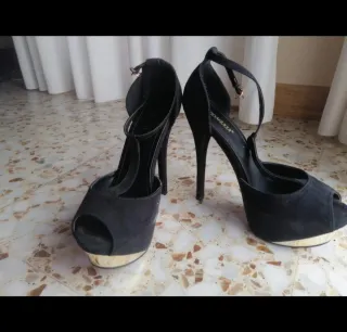 Tacones negros altos con plataforma dorada