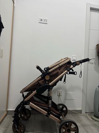 Carrito de bebé plegable color marrón.