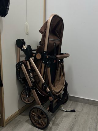 Carrito de bebé plegable color marrón.