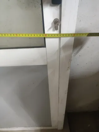 Puerta de aluminio con cristal y panel.