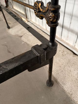 Cama de forja antigua con detalles florales