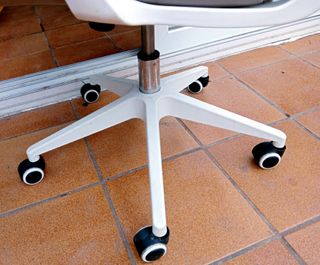 Silla de oficina giratoria beige con ruedas.
