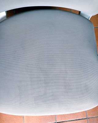 Silla de oficina giratoria beige con ruedas.