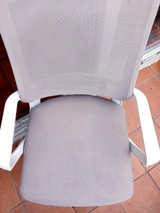 Silla de oficina giratoria beige con ruedas.